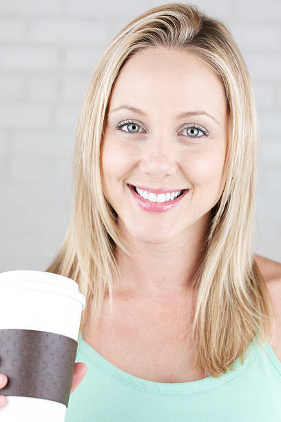 Smiling young woman with hot beverage cup