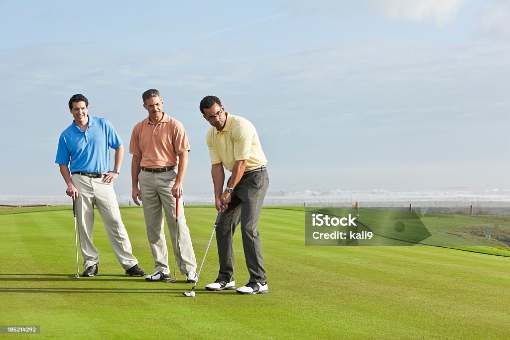 Hombres en golf course putting green - Foto de stock de Golf libre de derechos