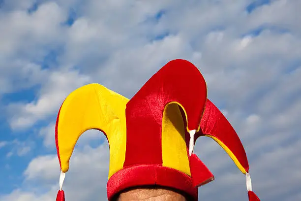 "football fans hat, yellow and red, cloudy sky."