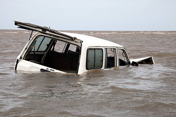 Abandoned bogged flooded and submerged car in sea water stock photo