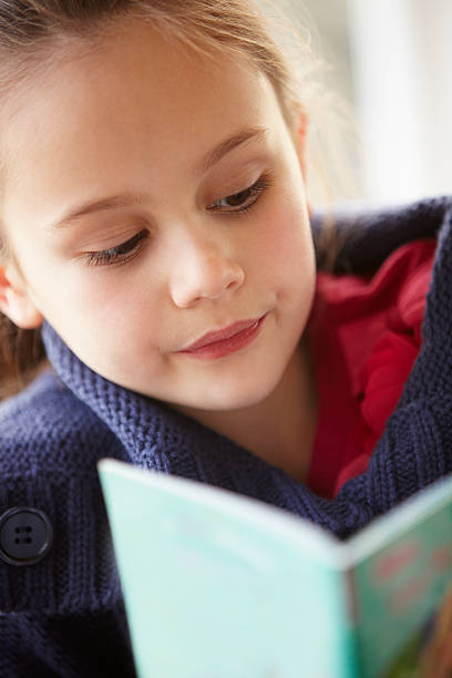 istock Young girl reading at home 185214800