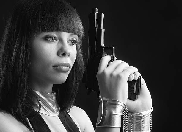 istock Pretty woman in manacles with a handgun. 185215194