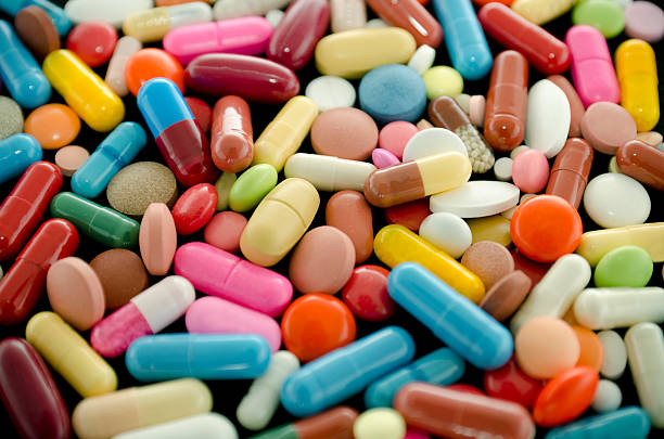 таблетки - pill multi colored capsule nutritional supplement стоковые фото и изображения