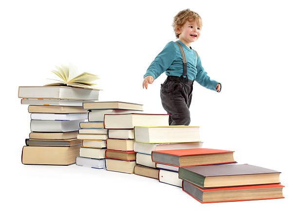 istock Cute baby Boy walking behind a Book Staircase 185215472