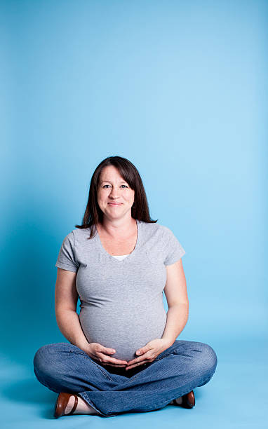 Pregnant Women Laughing While On Blue Background