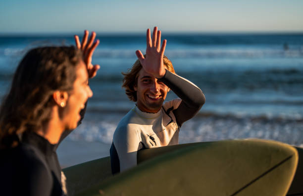 istock Two surfers with surfboard walking at beach preparing to hit the waves at sunset. 1852157835