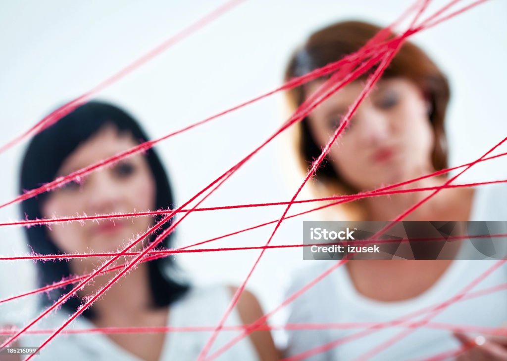 Network Network concept. Focus on the red rope with two women in the background. Adult Stock Photo