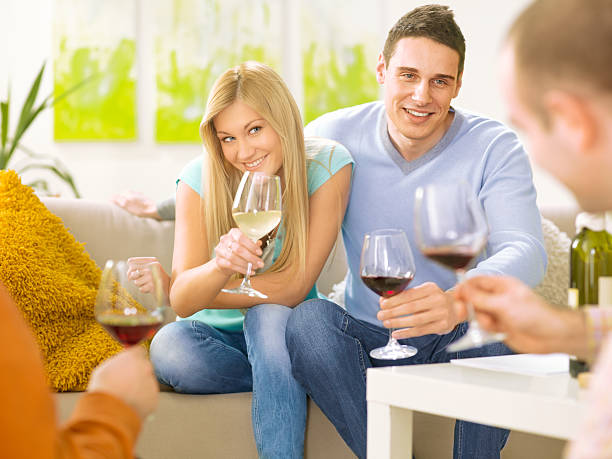 istock young couple having wine toast with friends 185216248