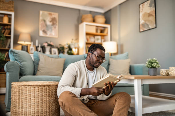 istock A smiling black man is reading a book and enjoying his new home 1852163231