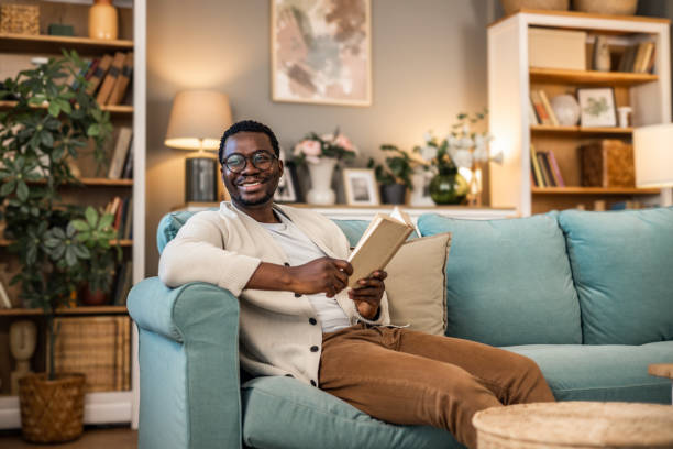 istock A man reading a book while sitting on the couch at home 1852163469
