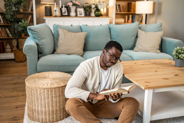 istock A smiling black man is reading a book and enjoying his new home 1852164404