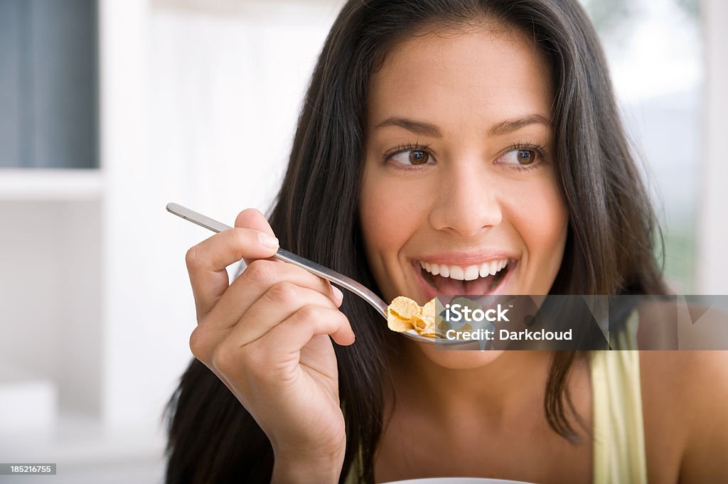 Eating cereal A beautiful woman eating cereal for breakfast. Adult Stock Photo