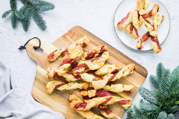 палочки для слоеного теста. крупный план слоеного теста с прошутто. - twisted cheese biscuit pastry стоковые фото и изображения