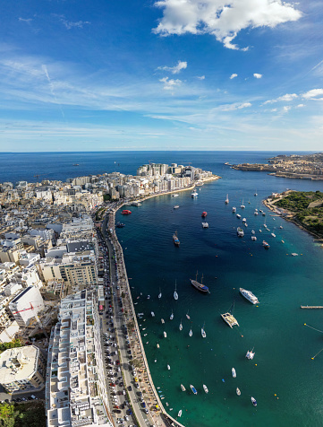 Discover Tigne Point in Sliema, Malta, overlooking the Mediterranean Sea with boats sailing on the blue ocean Surface. Seen a sunny day.