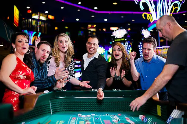 Stock photo of a group of people gambling at a craps table in a casino.