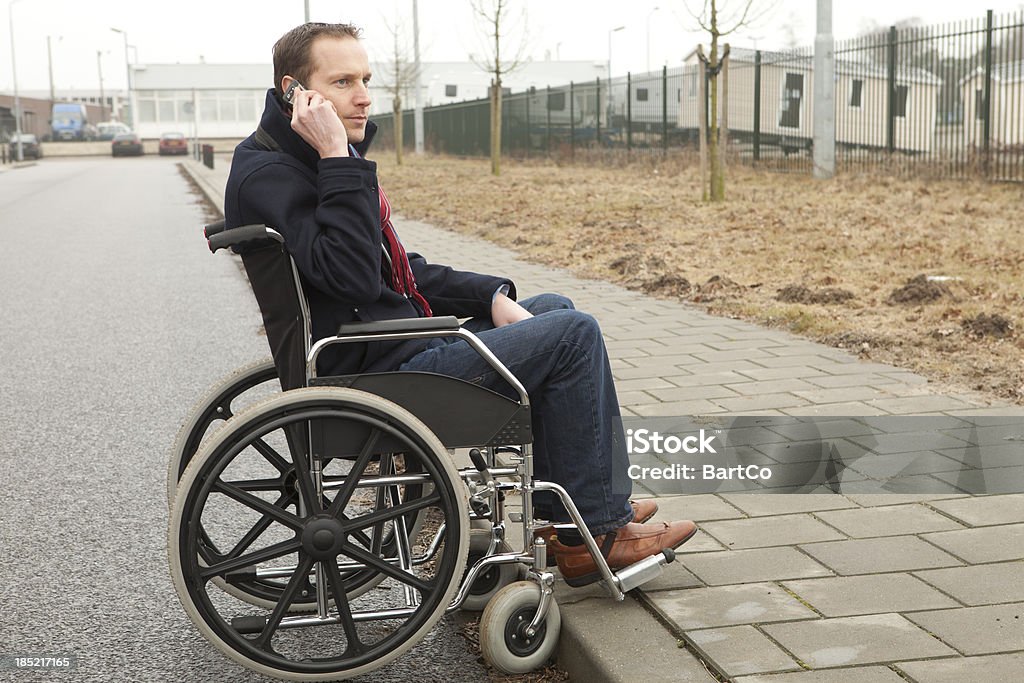 男性車椅子で無効になって屋外にてお電話で、ヘルプ - 弛緩のロイヤリティフリーストックフォト