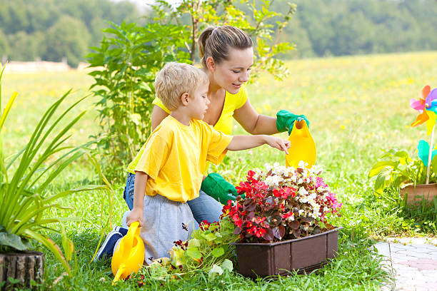 madre e figlio lavorando in giardino - formal garden ornamental garden child single flower foto e immagini stock