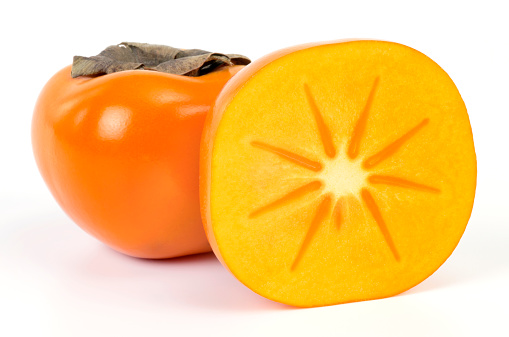 Fresh ripe, orange persimmons slices on a wooden background. Top view. Close-up.