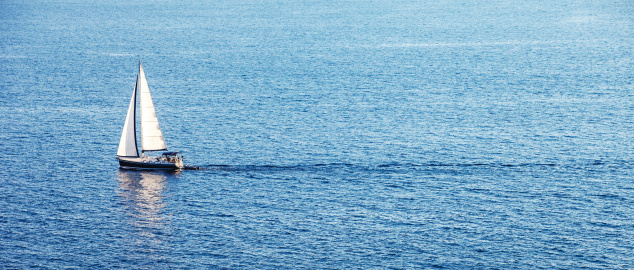Alone boat in the ocean. Blue Water. White Sail. Croatia