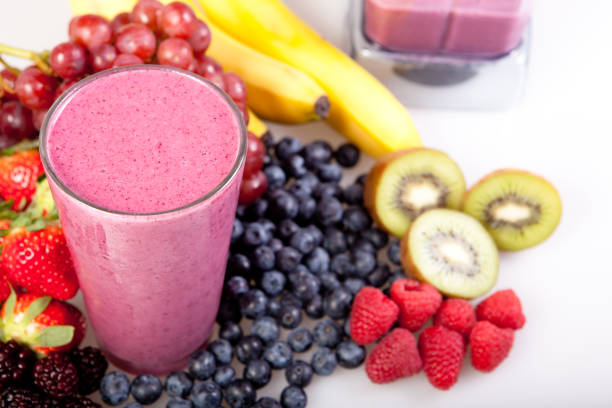 A fruit smoothie with fruit around it stock photo