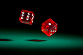 istock Red dice rolling on green felt. 185218555