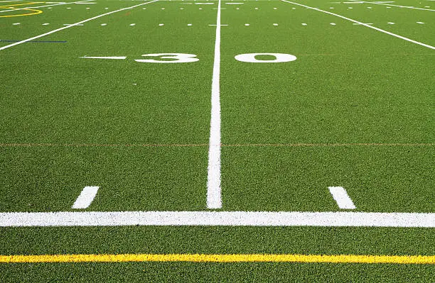 Yard line and other markings on a brand new astroturf American football field.