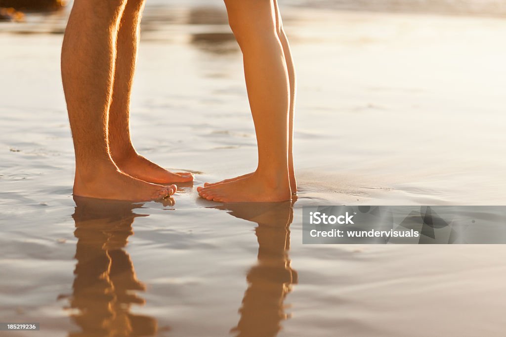 Couple's feet on Beach Low section of man and woman standing on beach about to kiss. Horizontal Shot. Please checkout our lightbox for more images Adult Stock Photo