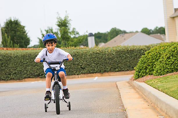 6 year old boy riding his bike in his neighborhood speeding. Motion blur.