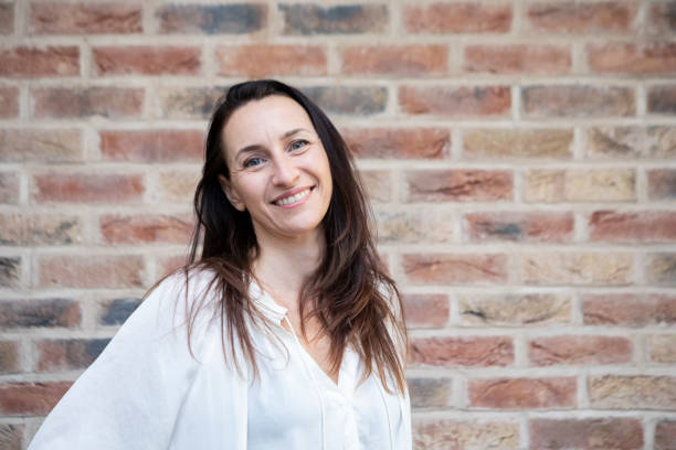 istock Cheerful woman standing by a brick wall 1852194489