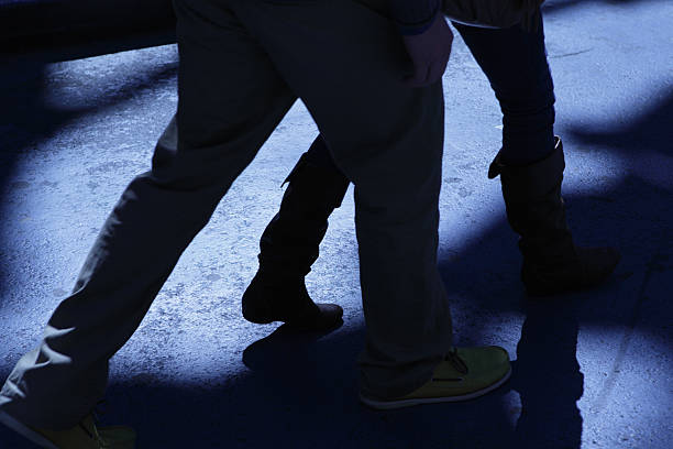 Male following attacking female in blue night shadows stock photo