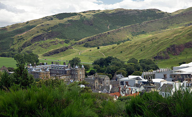 Edinburgh city buildings basking in warm sunlight with rugged arthur's seat and salisbury crags in the background