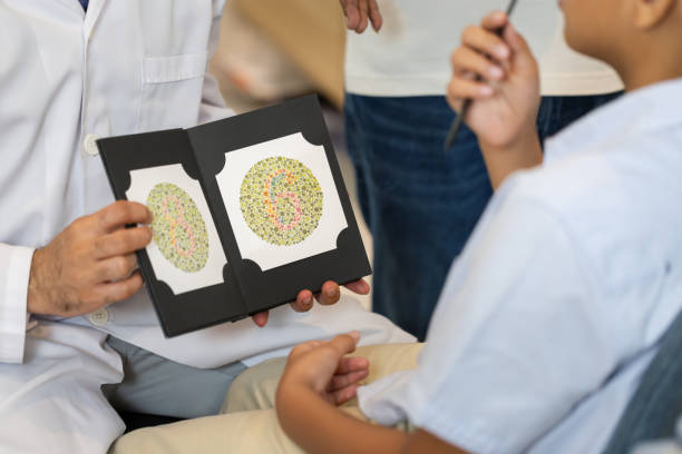istock Optometrist doing color blindness disease perception test in optical shop, Boy doing eye test checking examination with optometrist in optics store 1852214004