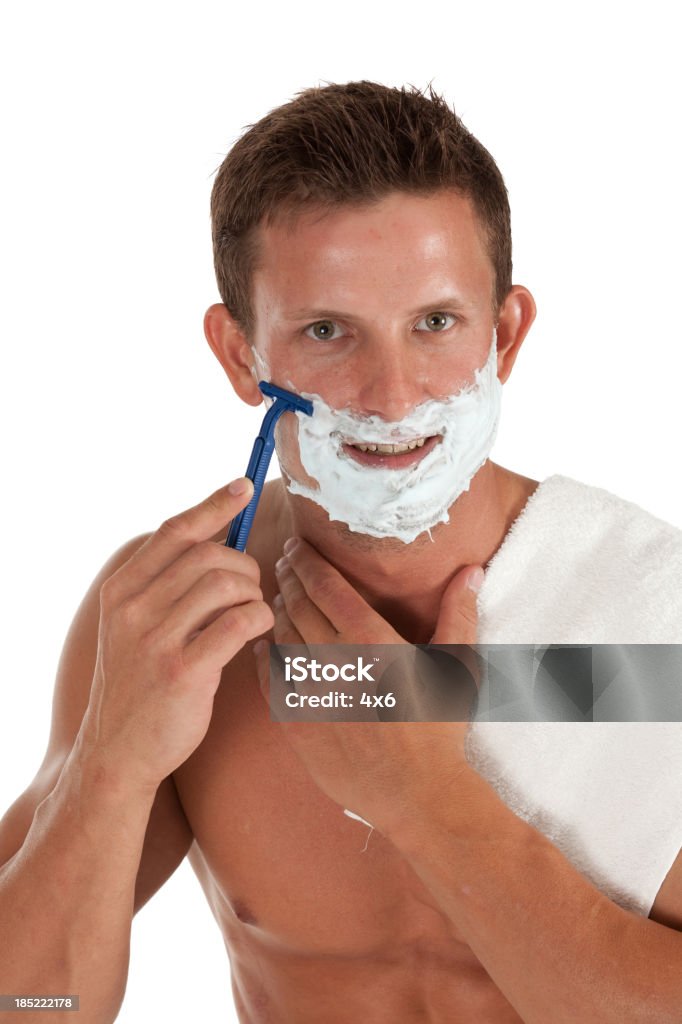 Attraente giovane uomo di rasatura con l'uso di rasoio - Foto stock royalty-free di A petto nudo
