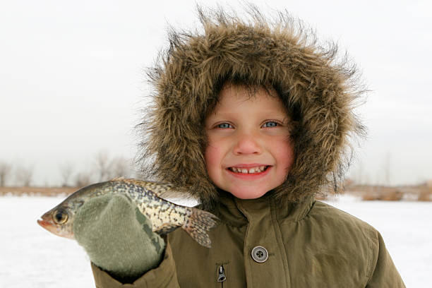 Boy pesca sobre hielo tiene pescado - foto de stock