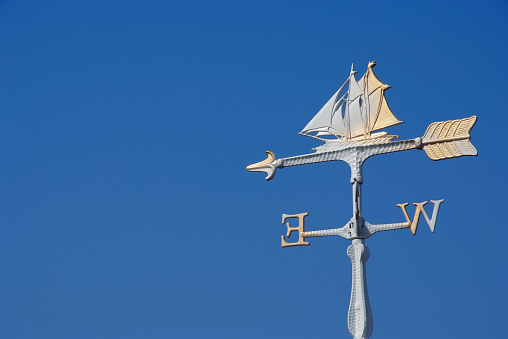 Sailboat wind vane against clear sky with copy space,