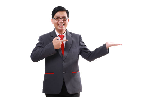 istock Happy asian businessman standing while pointing and presenting sideways. Isolated on white 1852223635