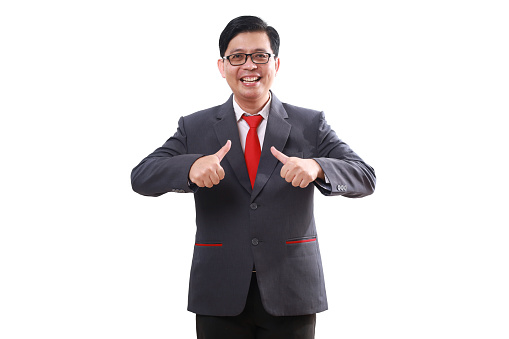 Happy satisfied asian businessman standing while showing thumbs up. Isolated on white