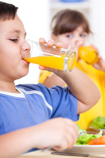 istock Children drinking orange juice 185222538