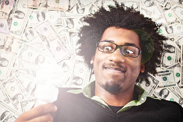 istock Wild-eyed young man with many dollars and light bulb 185223205