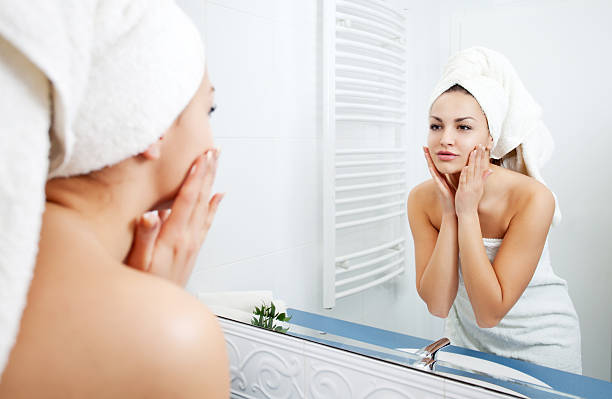 istock Woman applying moisturizer to her face. 185223209