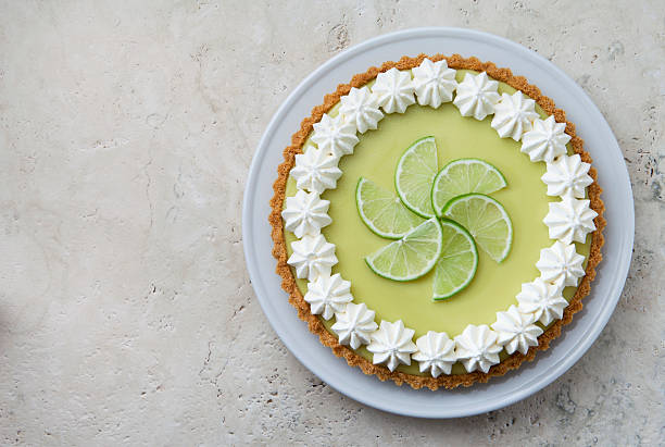 Key Lime Pie with Whipped Cream Rosettes and Lime Slices. stock photo