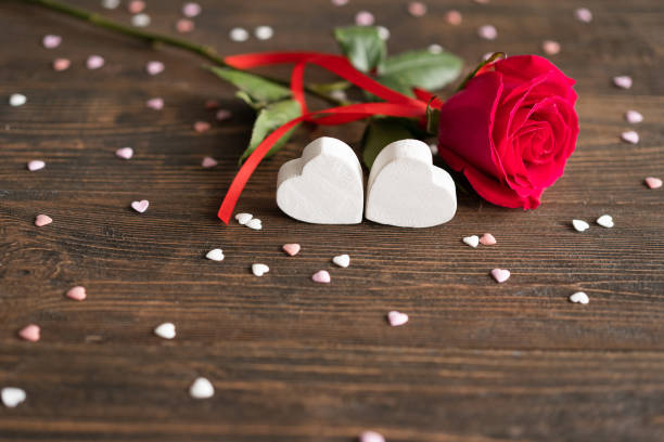 istock Red rose with postcard on wooden background 1852234835