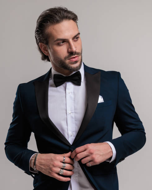 istock sexy young groom with beard looking to side and unbuttoning tuxedo 1852236438