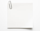 Blank white sticky note with paper clip on white background