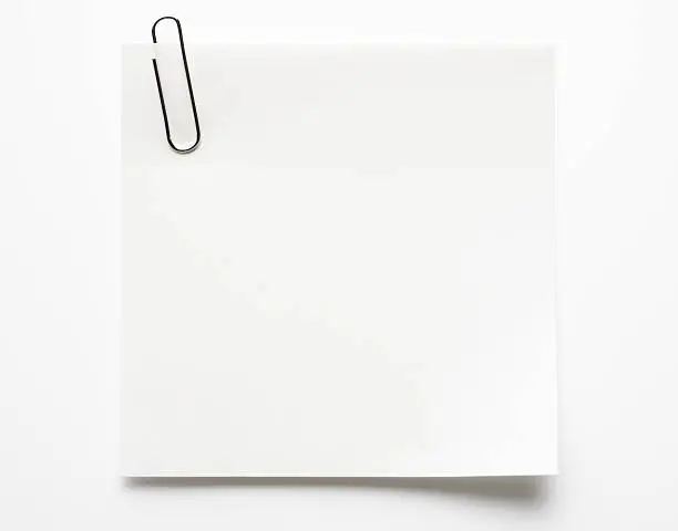 Photo of Blank white sticky note with paper clip on white background