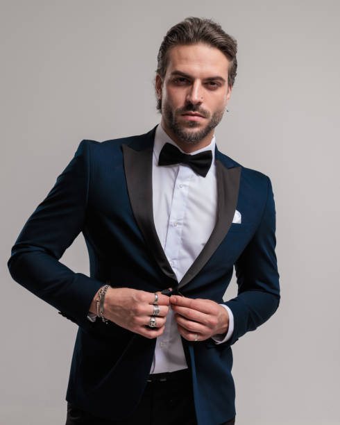istock confident young groom looking forward and arranging elegant tuxedo 1852238020