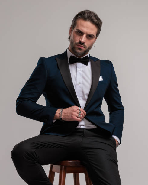 istock tough businessman buttoning tuxedo while looking forward and sitting 1852238026