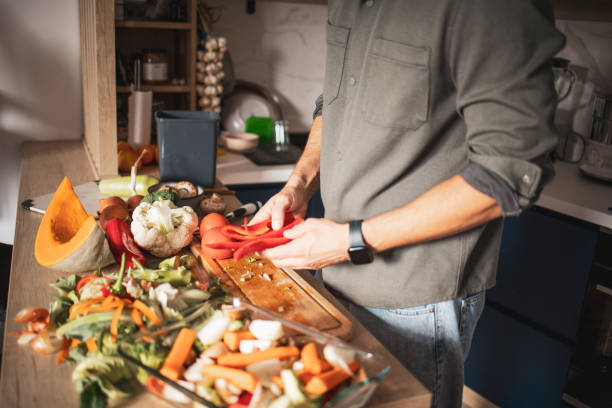 istock Man cooking vegetable meal at home. He is chopping vegetables and preparing compost 1852238027