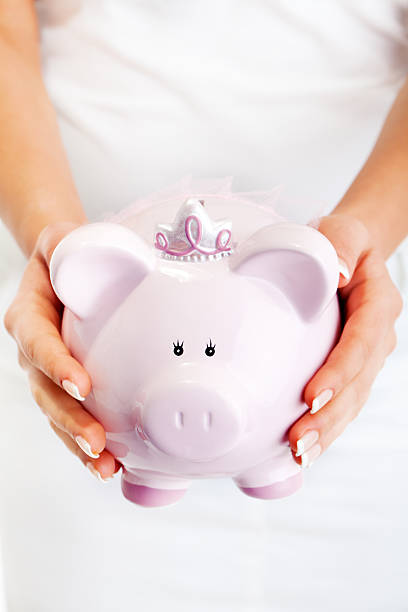 istock Woman holding pig money-box 185224576