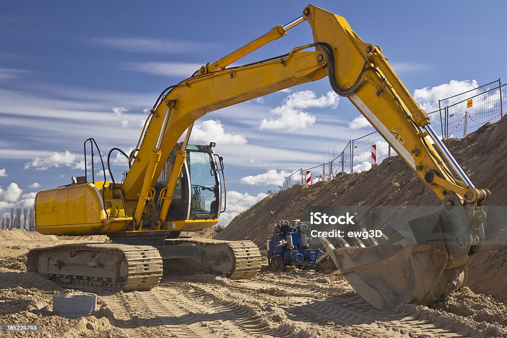 Yellow Excavator against blue sky Yellow Excavator in a new road construction against blue skySee more CONSTRUCTION MACHINERY images here: Backhoe Stock Photo